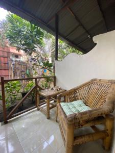 吉利特拉旺安Bintang Guesthouse的一个带长凳和桌子的门廊