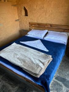 SāhiyaChaani Churani的一张带蓝色床单和白色枕头的床