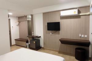 彭世洛友通酒店的酒店客房设有一张床和墙上的电视
