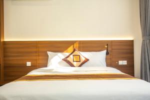 河内Sumitomo 15 Apartment - No 27 Lane 39 Linh Lang Street的一张带木制床头板和白色枕头的床
