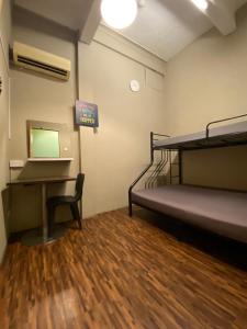 新加坡Backpacker Cozy Corner Guesthouse的客房配有双层床和书桌。