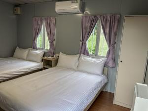 Yü-lan鉄木彩虹小屋的带2扇窗户的客房内的2张床