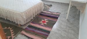 Chott MeriemDar Souade的一间位于床边的地板上,有两块地毯的房间