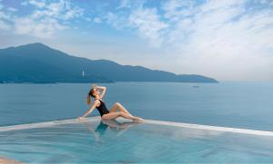岘港乐卡尔特岘港海滩酒店的坐在水中游泳池上的女人