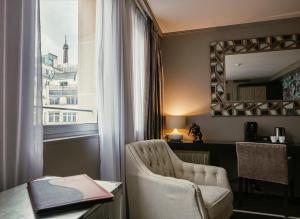 巴黎Juliana Hotel Paris的一间带椅子、窗户和镜子的房间