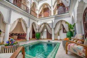 马拉喀什Riad Ekla Boutique Hotel的一座带大房间大楼内的室内游泳池