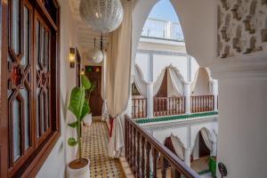 马拉喀什Riad Ekla Boutique Hotel的带有楼梯的走廊,位于一个种有盆栽植物的房子里