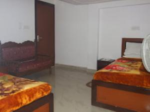 菩提伽耶Hotel Shiva , Bodh Gaya的一间卧室配有两张床和椅子