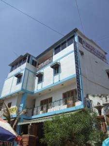 菩提伽耶Hotel Shiva , Bodh Gaya的蓝色和白色的建筑,设有阳台