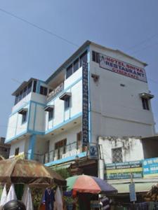 菩提伽耶Hotel Shiva , Bodh Gaya的一座白色的大建筑,上面有标志
