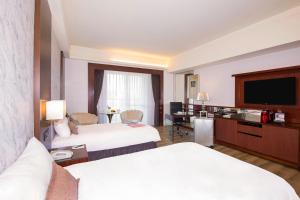台北台北汉普顿酒店的酒店客房设有两张床和一台平面电视。