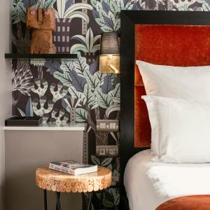 巴黎Juliana Hotel Paris的一间卧室配有一张床和一个带台灯的边桌