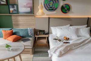 波普托Holiday Inn Resort Samui Bophut Beach, an IHG Hotel的一间卧室配有一张床、一张沙发和一张桌子