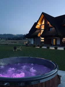 Białka TatrzanskaHill House Apartamenty的房屋前方装满紫色水的大浴缸