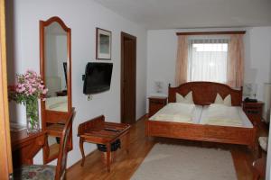 桑卡特弗洛里阿姆因圣弗洛里安酒店的一间卧室配有一张床、镜子和电视