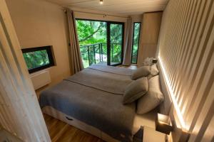 卡尔帕奇Treehouse Karpacz的一间卧室设有一张床和一个大窗户