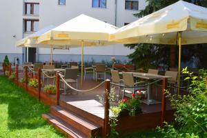 皮塞克毕欧格拉夫酒店的一个带遮阳伞和桌椅的庭院。