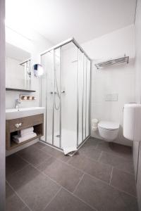 茨韦特尔FairSleep AVIA Motel Zwettl的带淋浴和卫生间的白色浴室