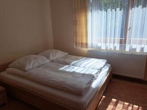 扎科帕内Willa Małgorzata pod skocznią的卧室内的一张未铺好的床,设有窗户