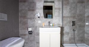 安塔利亚Cedrus Hotel的带淋浴、盥洗盆和卫生间的浴室