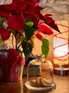 罗卡斯特拉达B&B Podere Camaiano的一张桌子,上面有花瓶,上面有红花和玻璃瓶