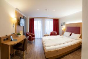 贝兴Zum Dallmayr Hotel Garni的配有一张床和一张书桌的酒店客房