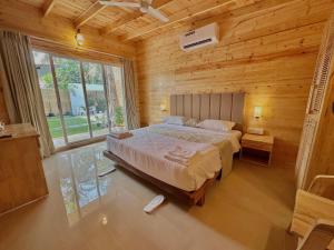 卡纳科纳The Nine Beach Resort的木制客房内的一间卧室配有一张大床