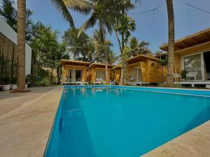 卡纳科纳The Nine Beach Resort的棕榈树屋前的游泳池