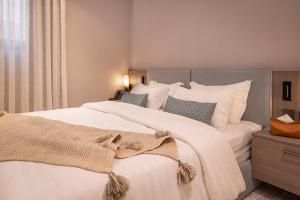 利雅德Viola Gardens Residence的卧室配有一张带白色床单和枕头的大床。