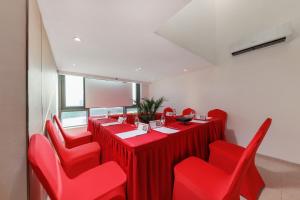 广州金舍名都国际公寓广州天河金融城三溪地铁站店的红色的用餐室配有红色的椅子和长桌