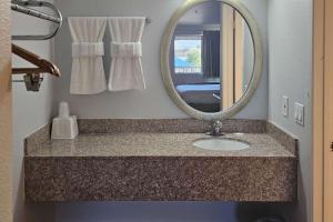 Thousand PalmsRodeway Inn & Suites Thousand Palms - Rancho Mirage的一间带水槽和镜子的浴室
