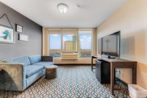尼亚加拉瀑布Wyndham Fallsview Hotel的客厅配有蓝色的沙发和电视
