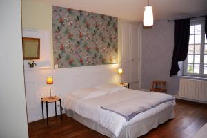 拉罗谢尔Petite Roche gîtes centre-ville La Rochelle的卧室配有一张床,墙上挂有绘画作品