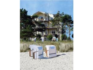 宾茨Panorama-Meerblick in der Villa Atlantic mit Strandkorb am Strand的一组沙滩椅,坐在房子前面的沙子上