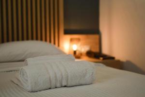 卡拉马塔Hotel Plaza的三条毛巾堆在床上