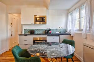 法莱斯La Casa Mathilda Elegant & soothing cocoon的厨房配有玻璃桌和两把绿色椅子