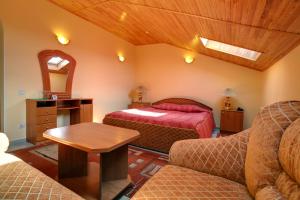 捷尔诺波尔鳄鱼水上乐园酒店的一间卧室配有一张床、一张沙发和一张桌子