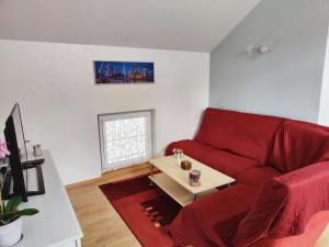 巴德尚Gîte Baldersheim, 4 pièces, 5 personnes - FR-1-744-6的客厅配有红色的沙发和桌子