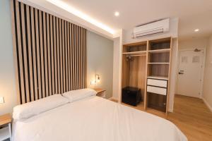 马德里I'M Room Suites Nuevos Ministerios - Bernabeu 'Digital Access'的卧室设有白色的床和大窗户