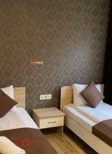 乌宗Aygün Suites Hotel&Bungalow UZUNGÖL的一间卧室设有两张床和床头柜