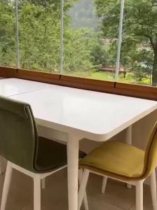 乌宗Aygün Suites Hotel&Bungalow UZUNGÖL的窗前的一张白色桌子和两把椅子
