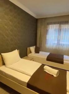 乌宗Aygün Suites Hotel&Bungalow UZUNGÖL的酒店客房设有两张床和一张桌子。