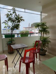 吉婆岛Galaxy Home - Hotel Sky view的植物阳台的两把椅子和一张桌子
