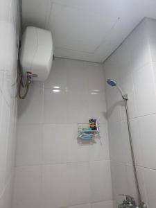贝克西Capital O 93490 Yubi Room Patraland的白色瓷砖浴室设有卫生间和淋浴。