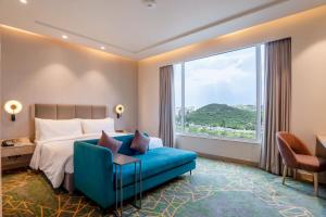 格德拉Holiday Inn Katra Vaishno Devi, an IHG Hotel的酒店客房设有一张床和一个大窗户