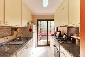 里斯本Charming apartment ideally located in Lisbon的厨房配有水槽和炉灶 顶部烤箱