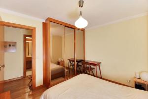 里斯本Charming apartment ideally located in Lisbon的一间卧室配有一张床、一张桌子和一面镜子