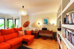 里斯本Charming apartment ideally located in Lisbon的客厅配有橙色沙发和书桌