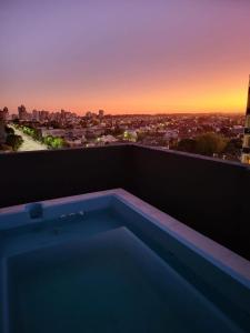 内科切阿NECOCHEA Centro MONOAMBIENTE PARA 2 PERSONAS的市景阳台的热水浴池