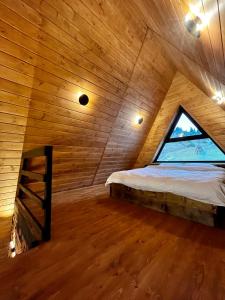 艾兹基Тихий куточок的木制客房的一张床位,设有窗户